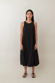 With its airy balloon silhouette that tapers gently at the hem, the Saffron Dress offers a playful and relaxed vibe. The dress has a simple sleeveless design with a round neckline and handy side pockets, perfect for stashing your essentials. The back zipper makes it easy to slip on and off, adding to its effortless appeal.