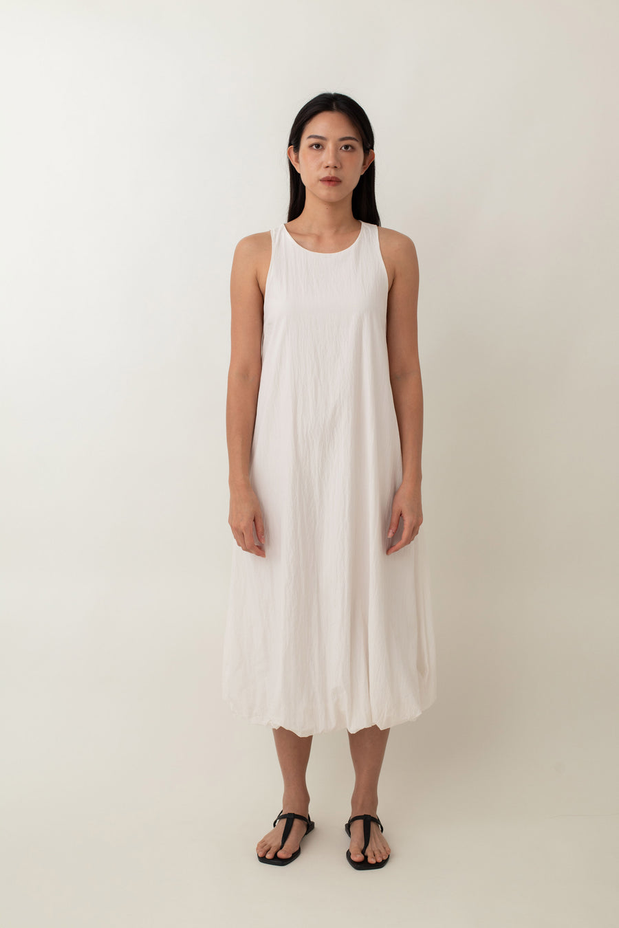 With its airy balloon silhouette that tapers gently at the hem, the Saffron Dress offers a playful and relaxed vibe. The dress has a simple sleeveless design with a round neckline and handy side pockets, perfect for stashing your essentials. The back zipper makes it easy to slip on and off, adding to its effortless appeal.