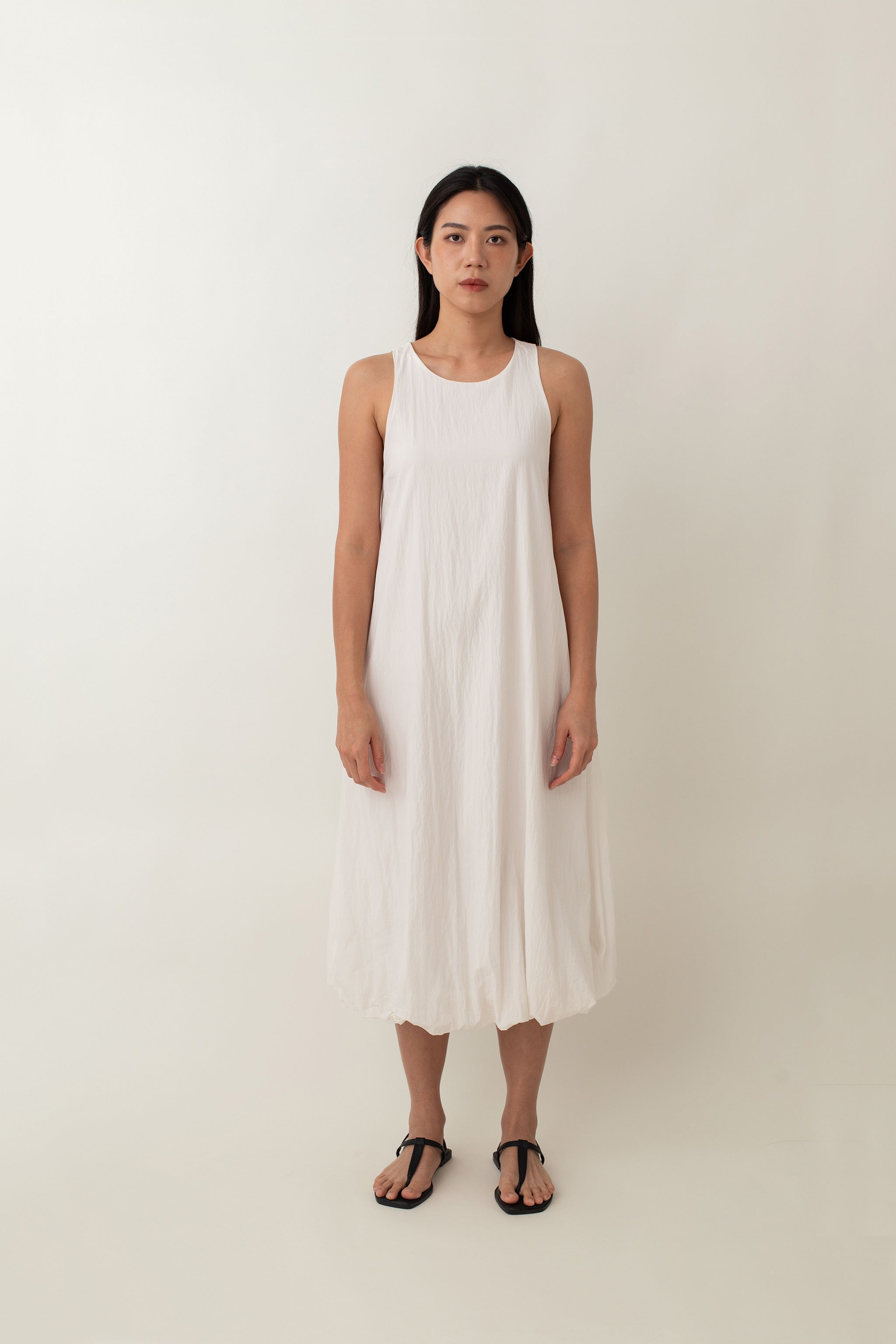 With its airy balloon silhouette that tapers gently at the hem, the Saffron Dress offers a playful and relaxed vibe. The dress has a simple sleeveless design with a round neckline and handy side pockets, perfect for stashing your essentials. The back zipper makes it easy to slip on and off, adding to its effortless appeal.